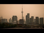 Replay À Toronto, la fumée des feux de forêt canadiennes teinte le ciel d'orange